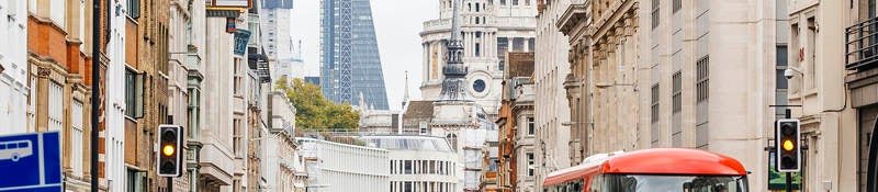 People walking on a busy street in London, England near St. Paul's Cathedral.